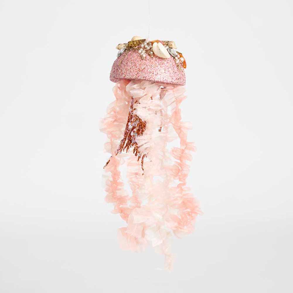 A pink jellyfish-shaped hanging ornament with a glittery pink cap, shell decorations, and long flowing translucent pink tentacles, shown against a plain light gray background.