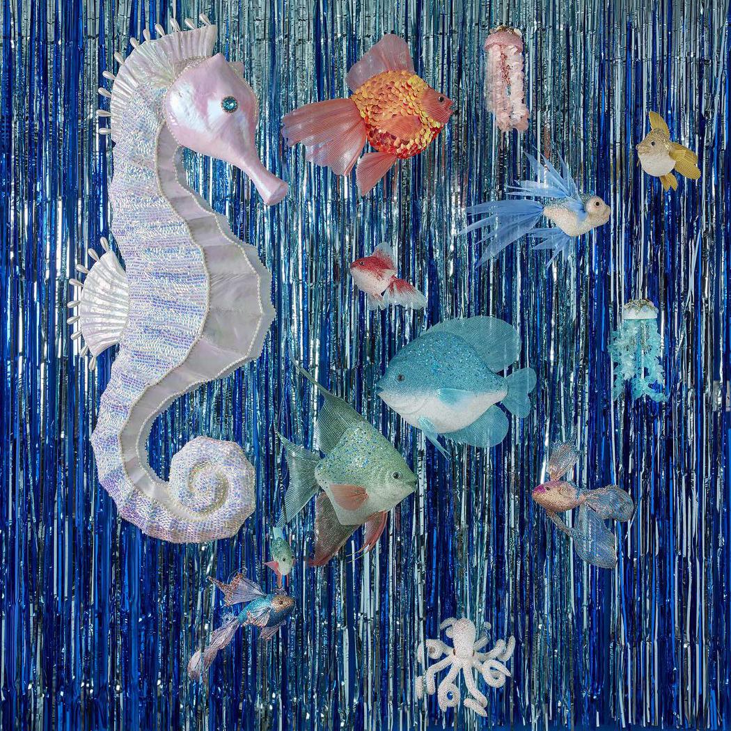 Decorative curtain with seahorse and fish patterns on a blue tinsel background