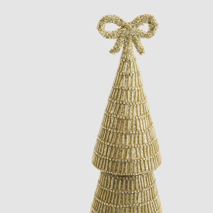 Gold beaded Christmas tree with a bow on a light gray background